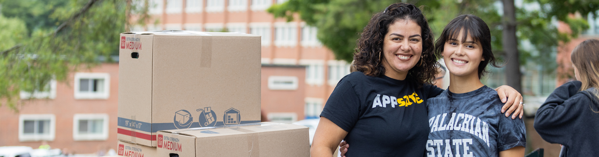 Smiling mother and daughter embrace during move-in day